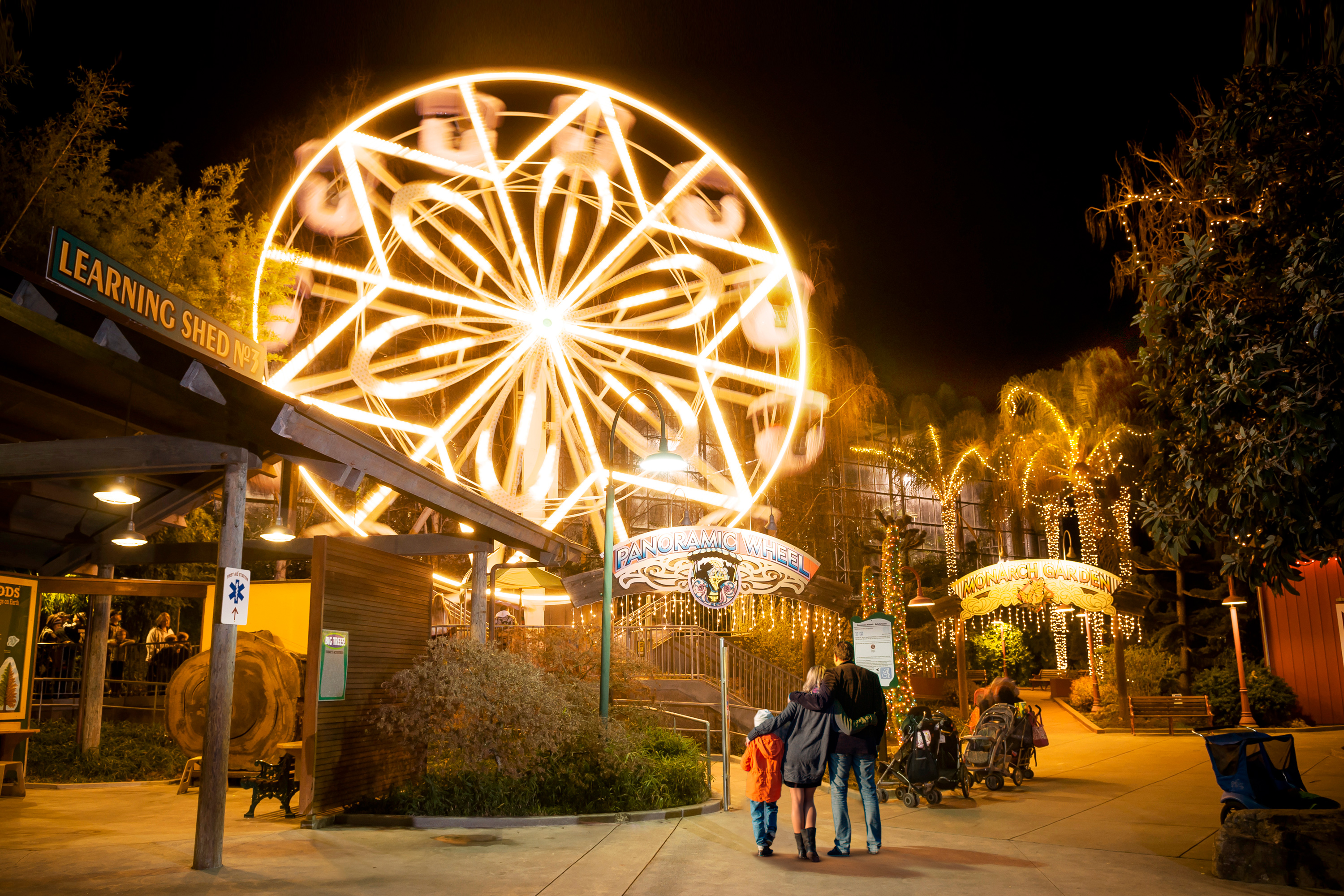 Family looking at the Panoramic Wheel lit up at Gilroy Gardens