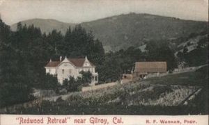 Picture of an old Victorian hotel called Redwood Retreat next to some vineyards and surrounded by trees