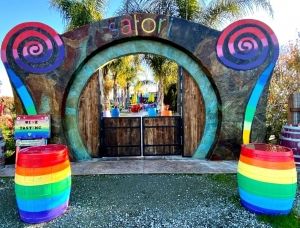 Rainbow-colored barrels and sign at Satori Cellars entrance