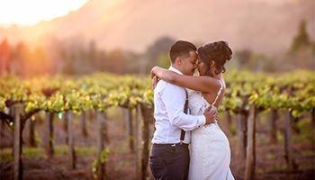 Bride and groom holding each other during sunet on a vineyard