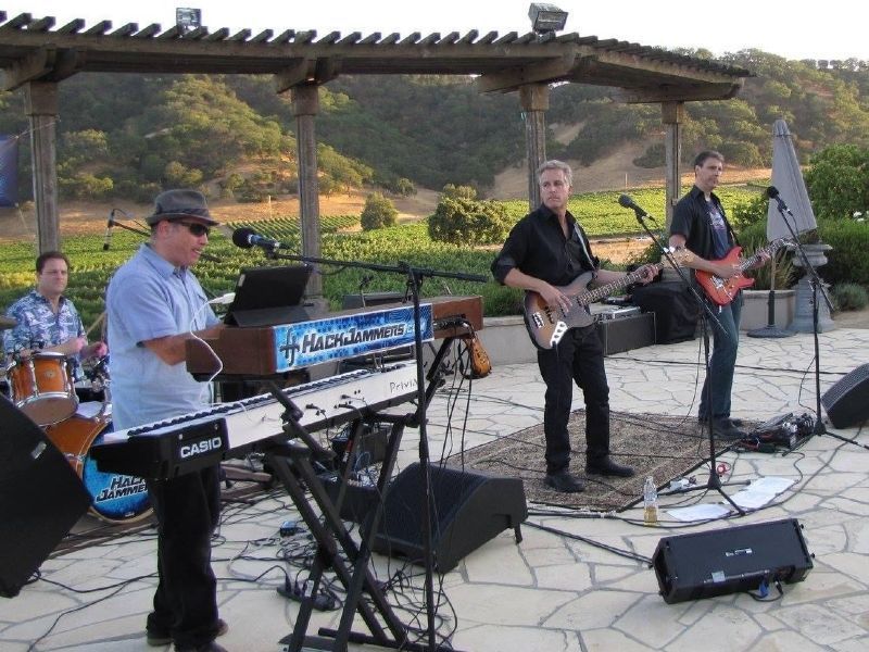 A band with four guys playing live outdoors on the patio at Clos la Chance winery