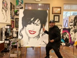 Nacho Moya of Moya Art Gallery And Studio poses with a painting