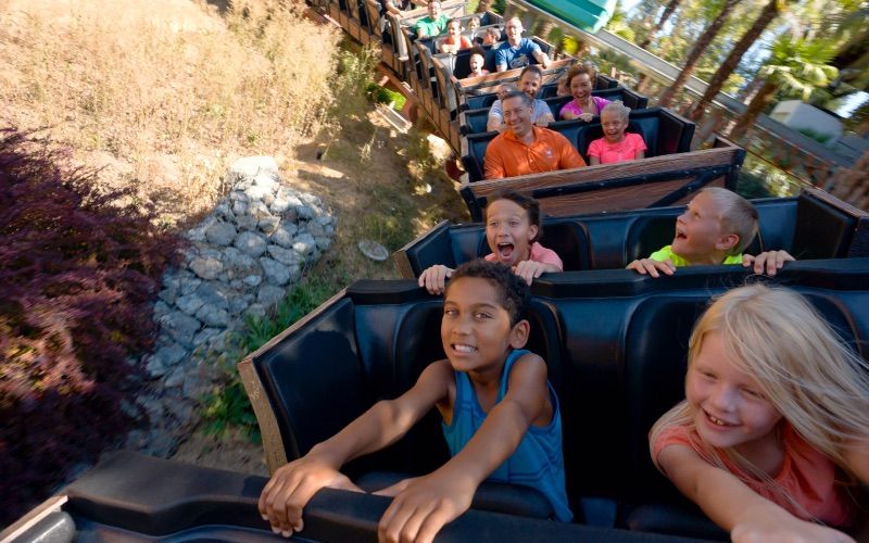 A bunch of kids and families riding on the Quicksilver roller coaster at Gilroy Gardens