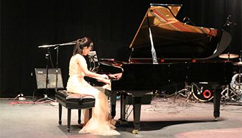 Girl wearing a white dress playing the piano