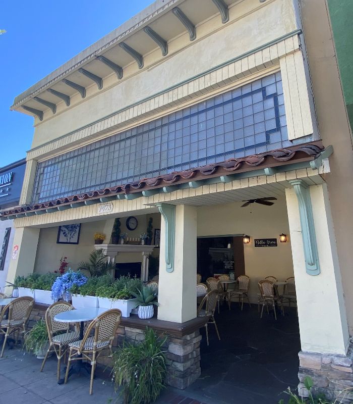 A Tuscan style building with glass tile windows above and an outdoor patio with fire place, Bella Viva Ristorante