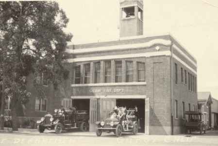 A black and white photo of the Old Fire Station 55 in Gilroy with two fire engines come out of the two large doors