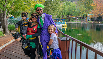 Family in costume smiling on a bridge at Gilroy Gardens Halloween