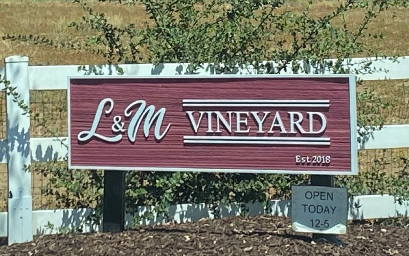A red sign with white lettering that says "L&M Vineyard"