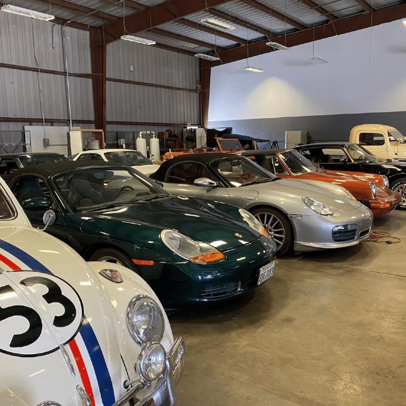 collectable cars lined up in a row in a large garage