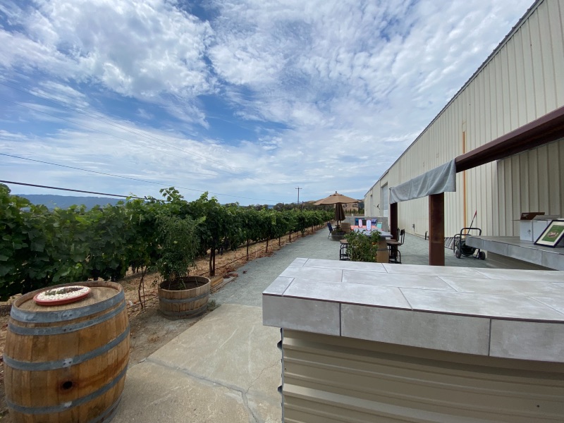 a wine barrel and vines with outdoor seating and a wine bar
