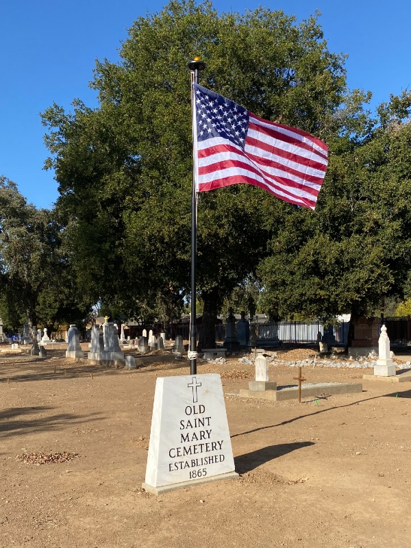 a momument for a cemetery with a US flag behind it