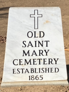 a marble monument with a black cross saying Old Saint Mary Cemetery