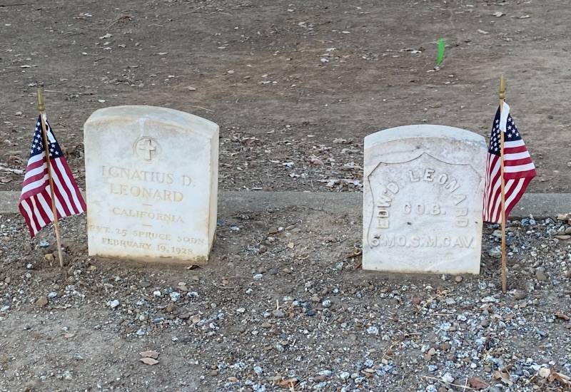 two gravestones with small US flags by them
