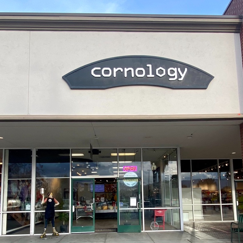 outside view of Cornology store with a mannequin out front holding popcorn
