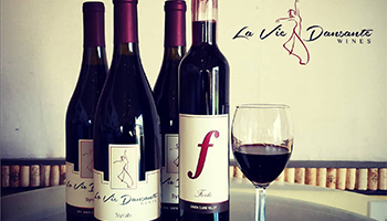La Vie Dansante Wine bottles and half full wine glass