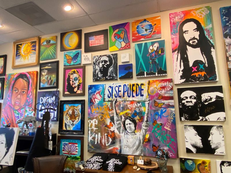 an art gallery wall covered in colorful bright paitings