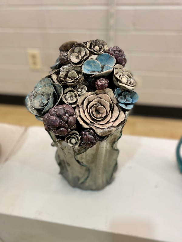 a gray sculpture of succulents with blue and purple accents