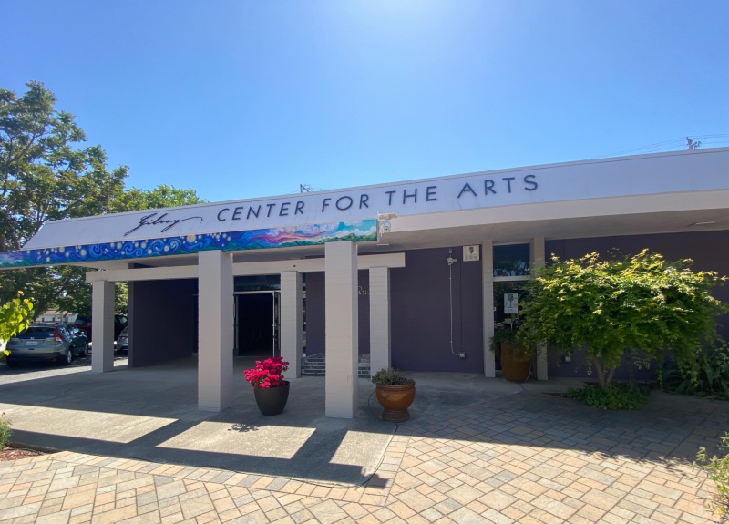 the exterior view of a purple building with white trim with a sign for Gilroy Center for the Arts