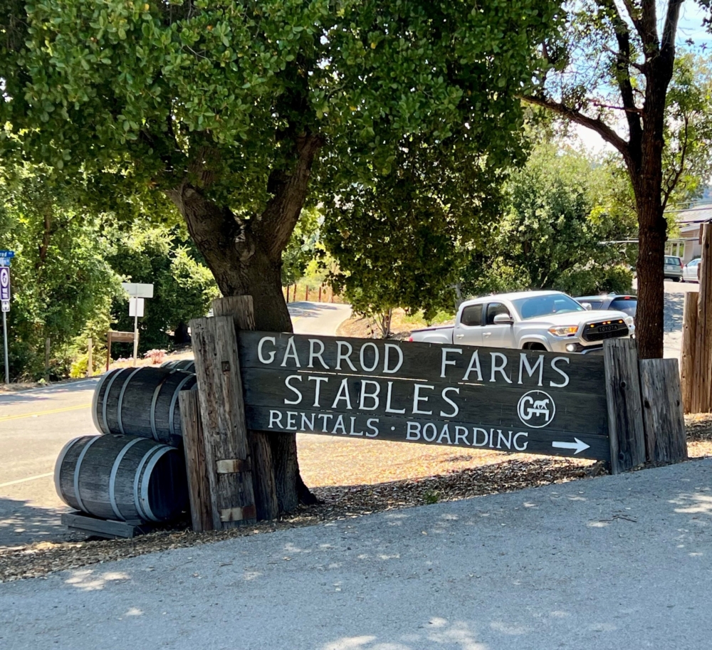 a large wooden sign pointing to the stables