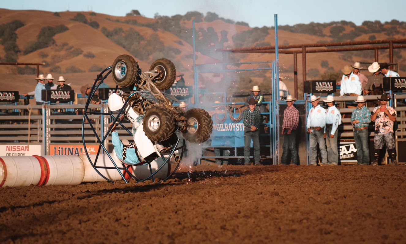 a man dressed as a cowboy clown is rolling a somersault on a quad with a frame around it
