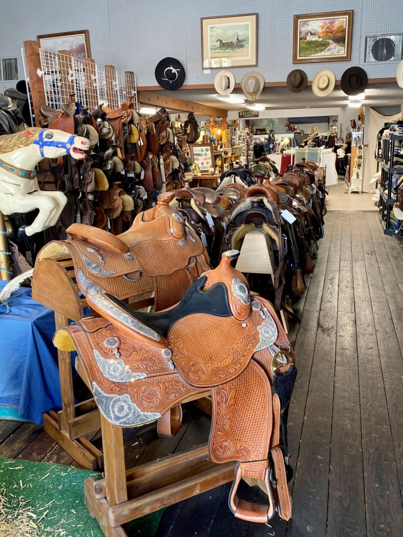 a western store with saddles, cowboy hats, and pictures on display